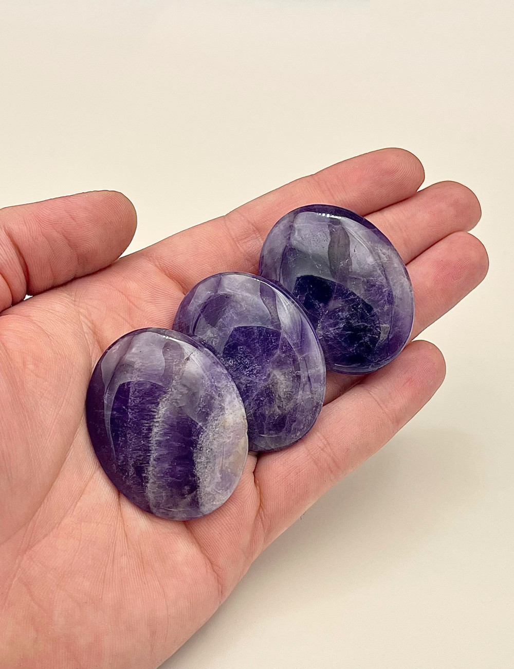 Rodado plano de Amatista natural pulido – vista principal en mano