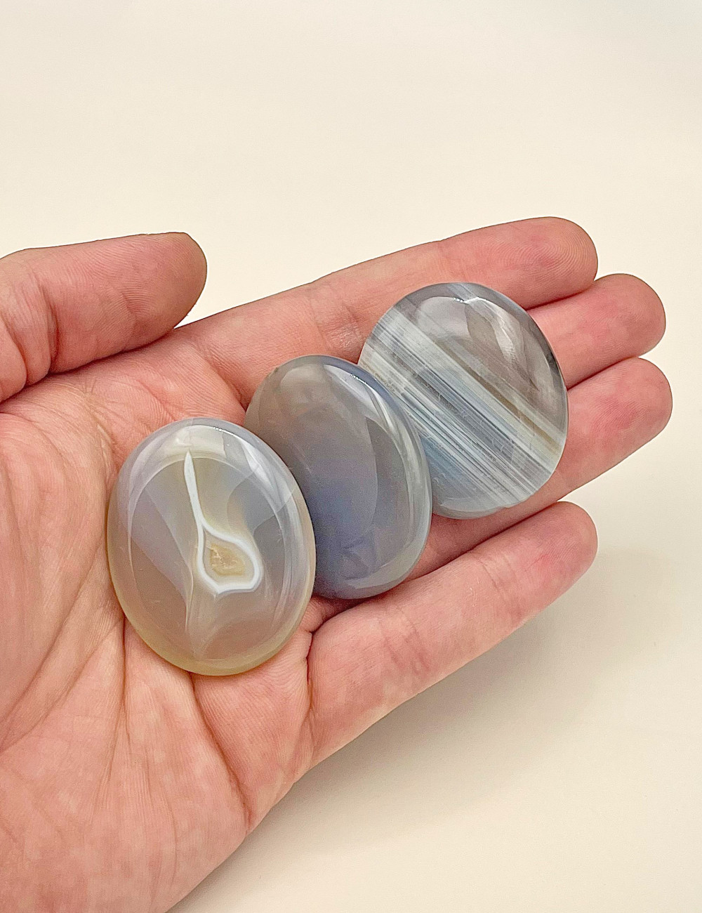 Rodado plano de Ágata gris natural  pulido – vista principal en mano