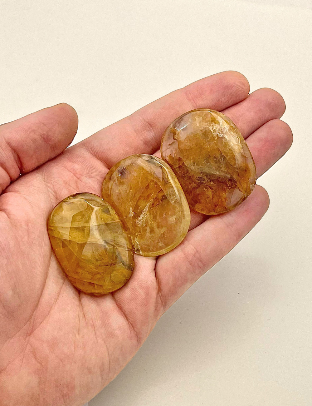 Rodado plano de Cuarzo Ferruginoso natural pulido – vista principal en mano