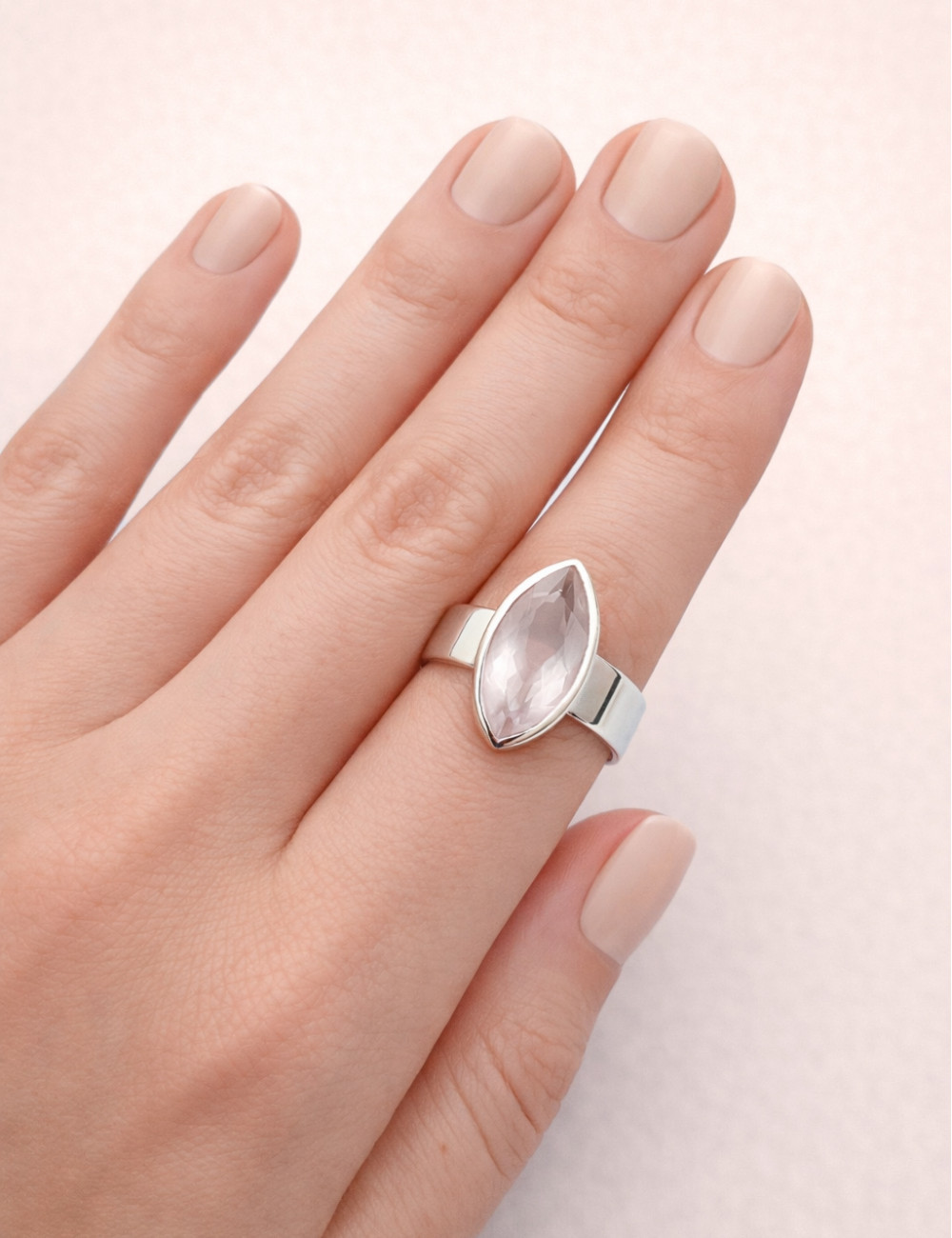 Anillo de cuarzo rosa natural tallado en plata en la mano