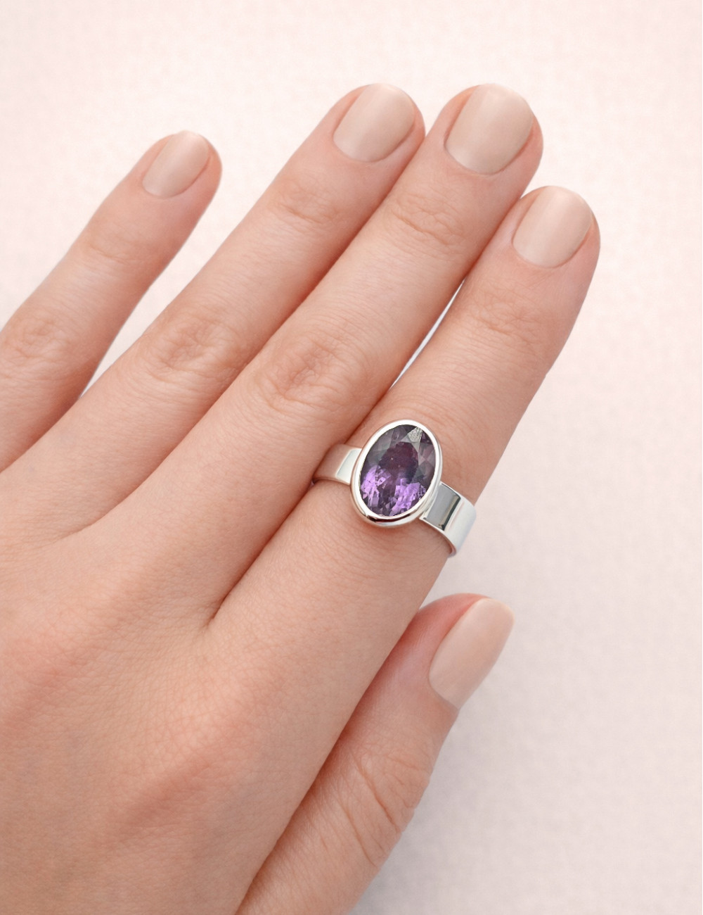 Anillo de Amatista natural tallado en plata en la mano