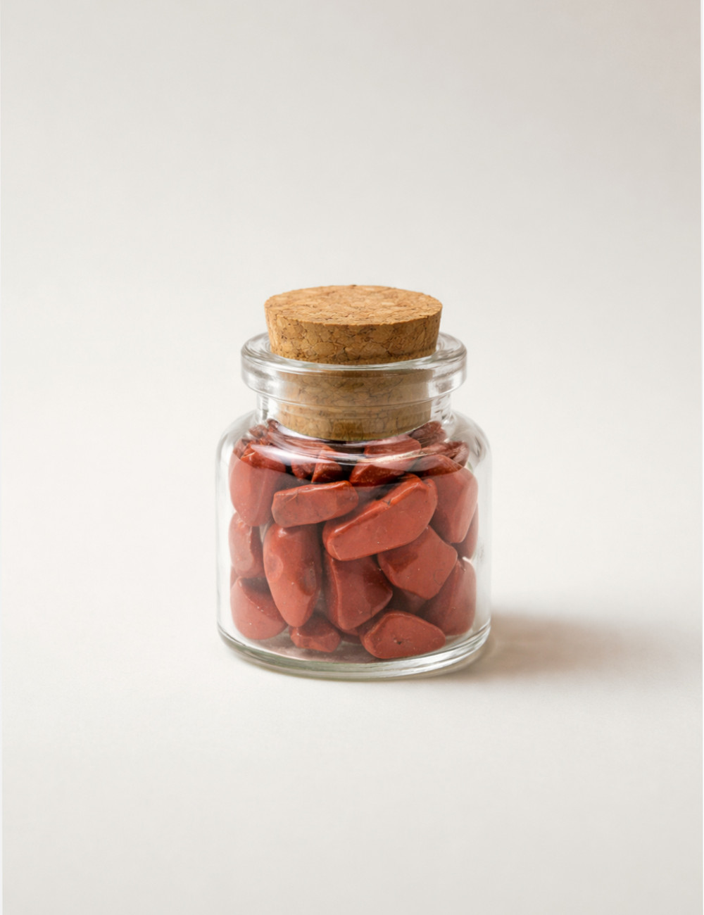 Chips de Jaspe rojo pulido natural presentado en un frasco mini de cristal con tapón de corcho