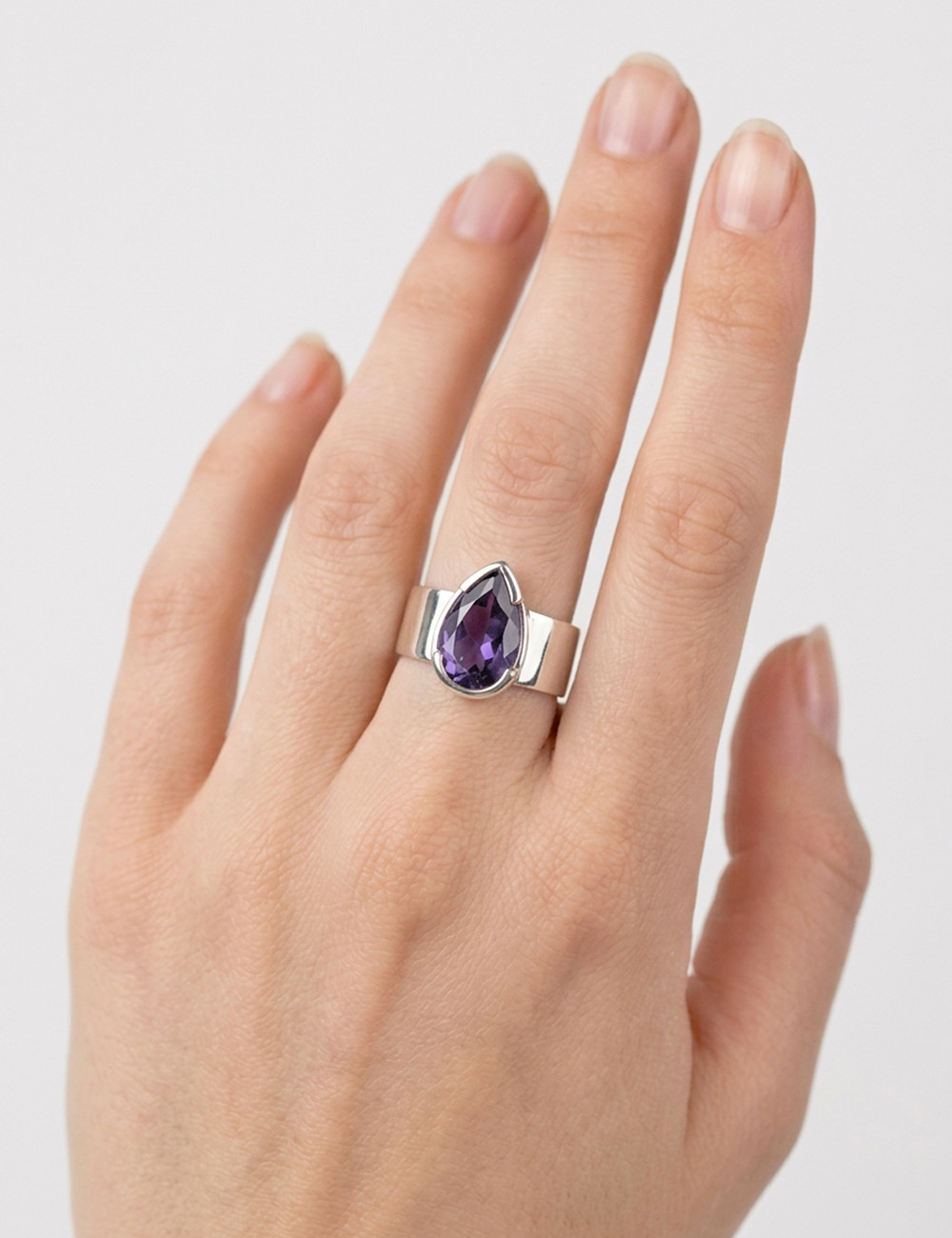 Anillo de Amatista natural tallado en plata en la mano