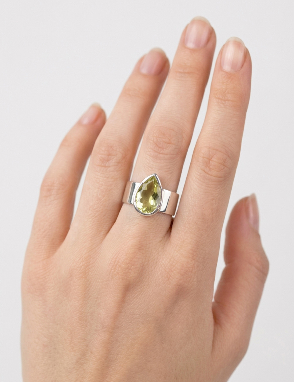 Anillo de cuarzo limón natural tallado en plata en la mano