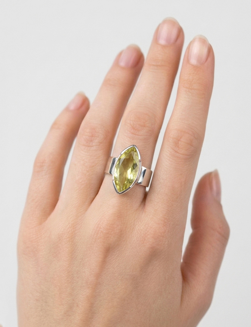 Anillo de cuarzo limón natural tallado en plata en la mano