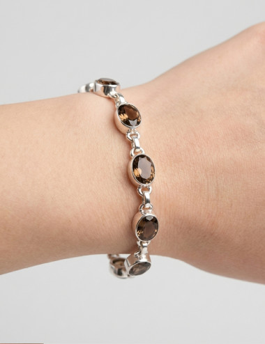 Pulsera de cuarzo ahumado tallado y plata en mano