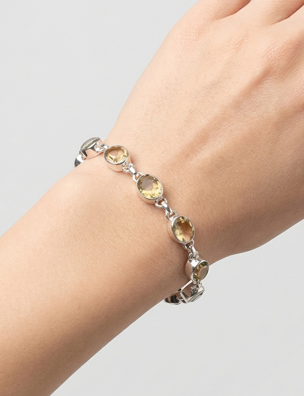 Pulsera de cuarzo citrino tallado y plata en mano